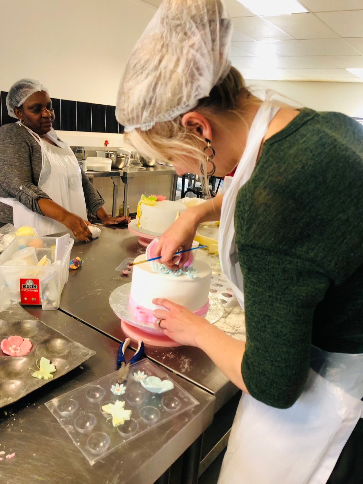 Student covering and decorating a birthday cake